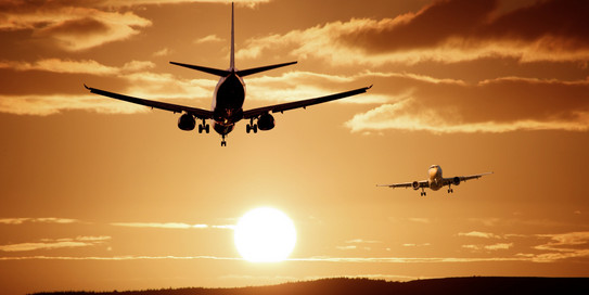 Mobilität Zwei Flugzeuge vor einem Sonnenuntergang