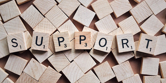 Spielsteine mit Buchstaben, die das Wort „Support“ bilden