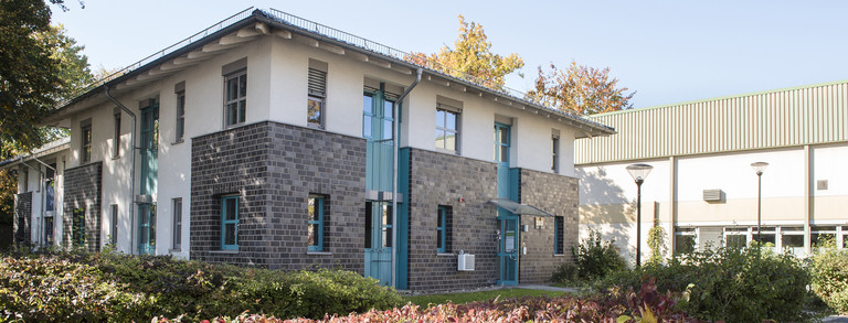 Baroper Straße 283 - Zweistöckiges Gebäude mit grau-weißer Fassade und türkisen Fensterrahmen